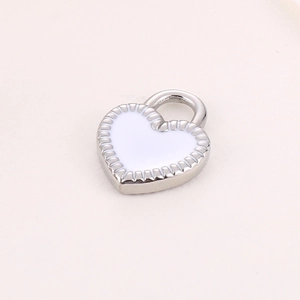 Macro detail of a heart-shaped silver pendant with white enamel finish for jewelry making