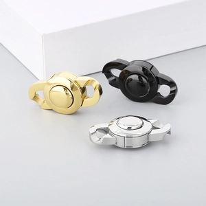 Three-color Cuban chain buckles in gold, black, and silver finishes on a grey surface