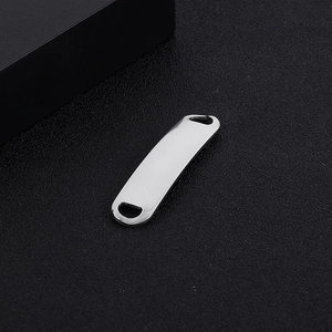 Macro shot of silver curved stainless steel bar with dual holes for DIY jewelry