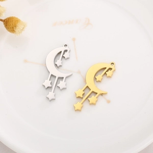 Detailed view of silver and gold moon and stars tassel charms on a ceramic plate