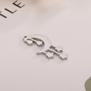 Macro shot of silver stainless steel crescent moon pendant with five small star charms