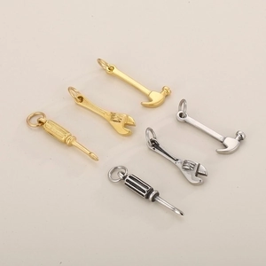 Set of six gold and silver metal charms featuring hammer wrench and screwdriver tools