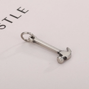 Macro shot of silver hammer tool pendant with polished finish and detailed metal handle