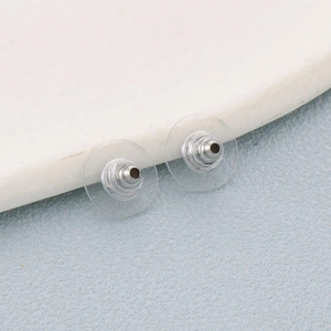 Macro view of transparent silicone and silver stainless steel flying saucer earring backs