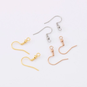 Macro detail of gold, silver, and rose gold stainless steel fish hook earrings with coil