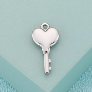 Macro shot of polished silver heart-shaped key pendant for DIY stainless steel jewelry