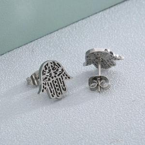 Detailed macro view of silver hollow Hamsa Hand stud earrings with butterfly backs