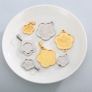 Detailed flat lay of flower shaped stainless steel pendants in gold and silver finish