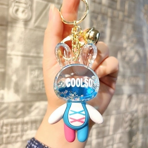 Close-up of cute acrylic liquid rabbit keychain with blue glitter stars and gold bell