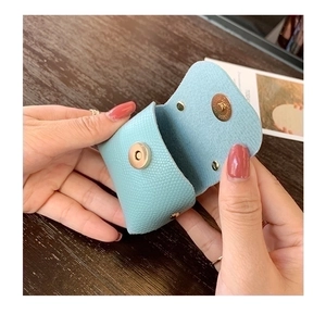 Close-up of light blue leather mini pouch with golden magnetic snap closure for bags