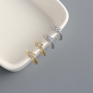 Macro shot of gold and silver S925 sterling silver star ear cuffs with zircon inlays