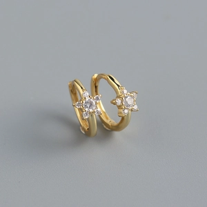 Macro shot of gold S925 silver huggie earrings with sparkling star-shaped zircon stones