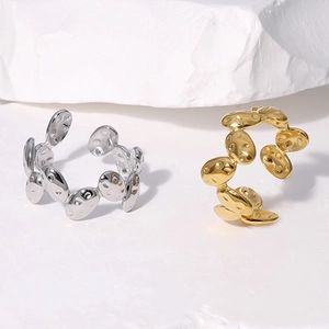 Detailed view of silver and gold textured rings on white stone background