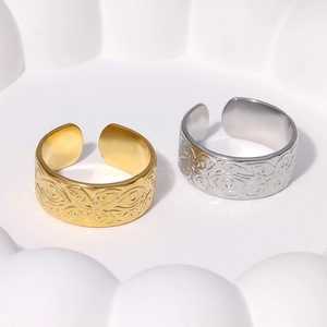 Close-up of gold and silver evil eye rings with embossed details on a white tray