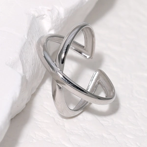 Minimalist silver crisscross adjustable stainless steel ring on white stone base