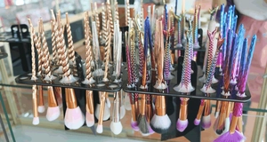 Close-up of makeup brush collection with unicorn and mermaid handles in colorful finishes