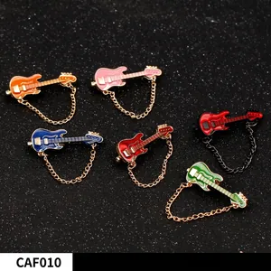 Set of six colorful guitar brooches with fine metal chains on dark glitter background