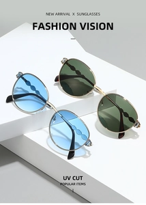 Détail de montures de lunettes de soleil en métal doré avec branches ondulées et cristaux
