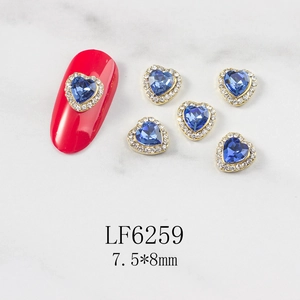 Macro detail of 3D heart-shaped blue nail art crystals with gold metal base 7.5x8mm