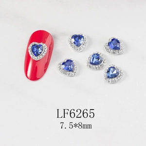 Detailed view of 7.5x8mm blue heart crystal nail charm with silver base for manicure