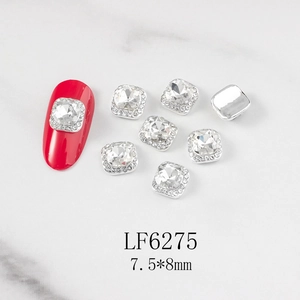 Macro shot of silver square nail art charms with heart crystal and size labels