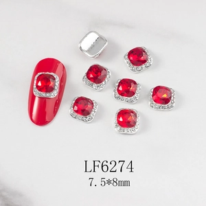 Detail view of 7.5x8mm square red zircon nail charms with silver metal claw and rhinestones