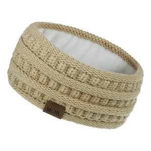 Detail of warm winter cable knit headband with soft white fleece lining and MOK leather patch