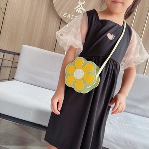Petite fille portant un sac bandoulière coloré en forme de fleur en cuir jaune et vert
