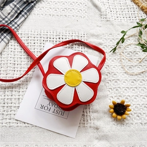 Détail du sac enfant en forme de fleur rouge avec pétales blancs et bandoulière