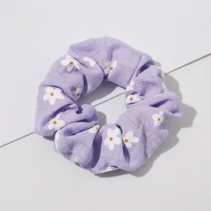 Macro detail of lavender daisy print scrunchie showing fabric texture and pleats