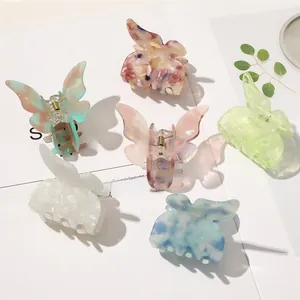 Detailed overhead shot of six elegant butterfly hair claws in various acetate patterns