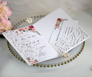 Macro detail of laser-cut white wedding invitation with elegant floral lace pattern