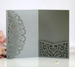 Macro view of grey laser-cut wedding invitation with elegant floral lace hollow pattern