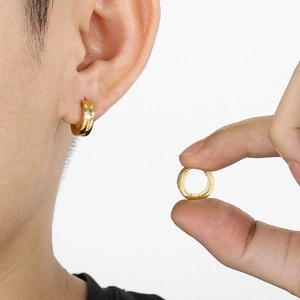 Detail of a gold plated huggie earring featuring a sparkling inset solitaire cubic zirconia