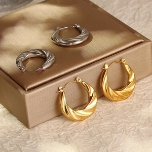 Chic twisted gold and silver hoop earrings in a minimalist stainless steel spiral design