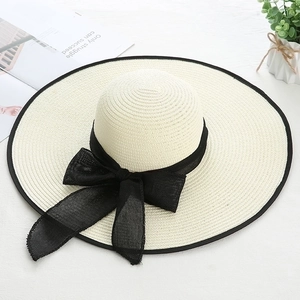 Chic cream straw sun hat with black bow ribbon and wide brim for summer beach vacation