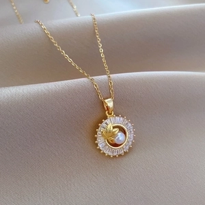 Detailed macro view of gold necklace with halo diamond pendant and center pearl on silk