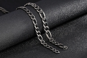 Macro detail of polished stainless steel Figaro chain with silver-grey vintage finish