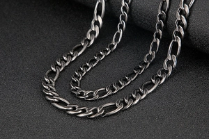 Detail of three vintage stainless steel Figaro chains with polished metallic finish