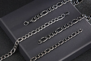 Macro detail of gunmetal Figaro chain necklace with a durable lobster clasp for men
