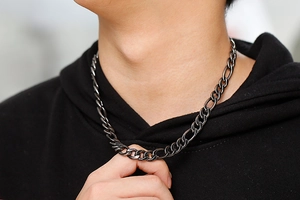 Detail of vintage figaro necklace in gunmetal stainless steel worn with black hoodie
