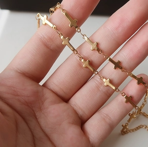 Detail of gold-plated cross link necklace featuring a lobster clasp and adjustable tail chain