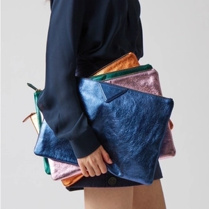 Chic metallic PU leather envelope clutch bags in vibrant colors held by a model