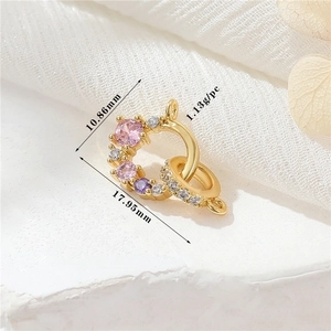 Detailed macro view of 14K gold pendant link with pink and purple inlaid stones