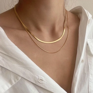 Three-layer gold snake bone necklace in stainless steel on a model wearing white