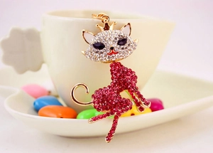 Close-up of a sparkling cat keychain with red and clear rhinestones and golden crown