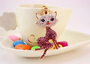 Close-up of golden cat keychain with purple rhinestones and small crown detail