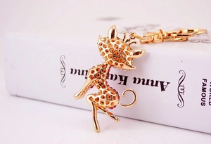 Detailed close-up of a gold hollow giraffe keychain with red sparkling rhinestones