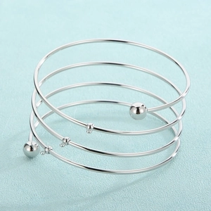 Macro shot of silver multi-layer spiral bangle with DIY charms hanging rings