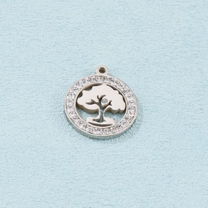Close-up of a silver tree of life pendant with white crystals on a blue texture background